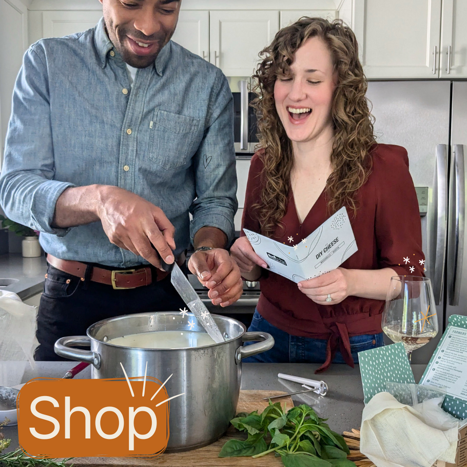 young multiracial couple making cheese in a kitchen laughing