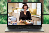 Laptop displaying a woman in a kitchen with a blurred green outdoor background