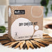 DIY cheese kit packaging on a wooden coaster with blurred background