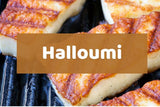 Grilled halloumi cheese slices with golden-brown charred marks on a dark grill, overlaid with a semi-transparent brown banner containing the white text 'Halloumi'.