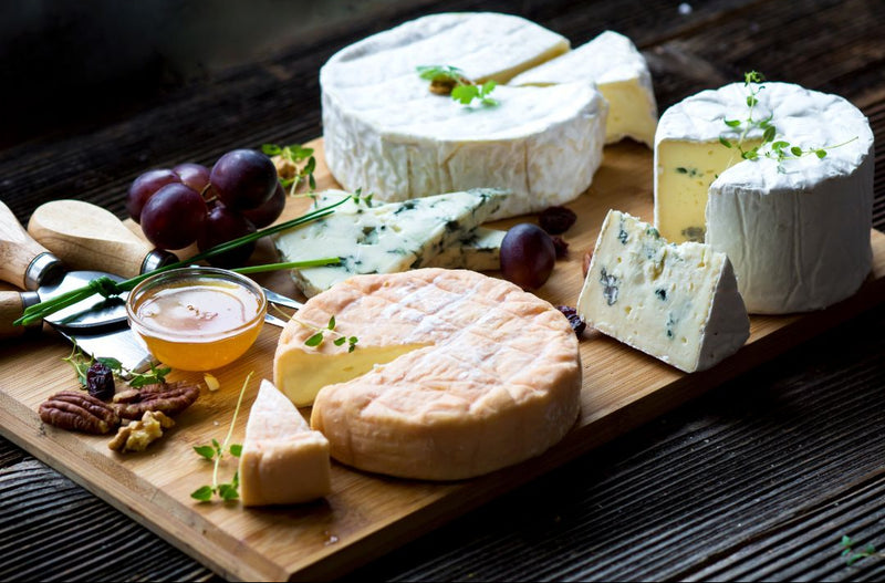 wood platter of moldy cheeses blue white bloomy and b linens 